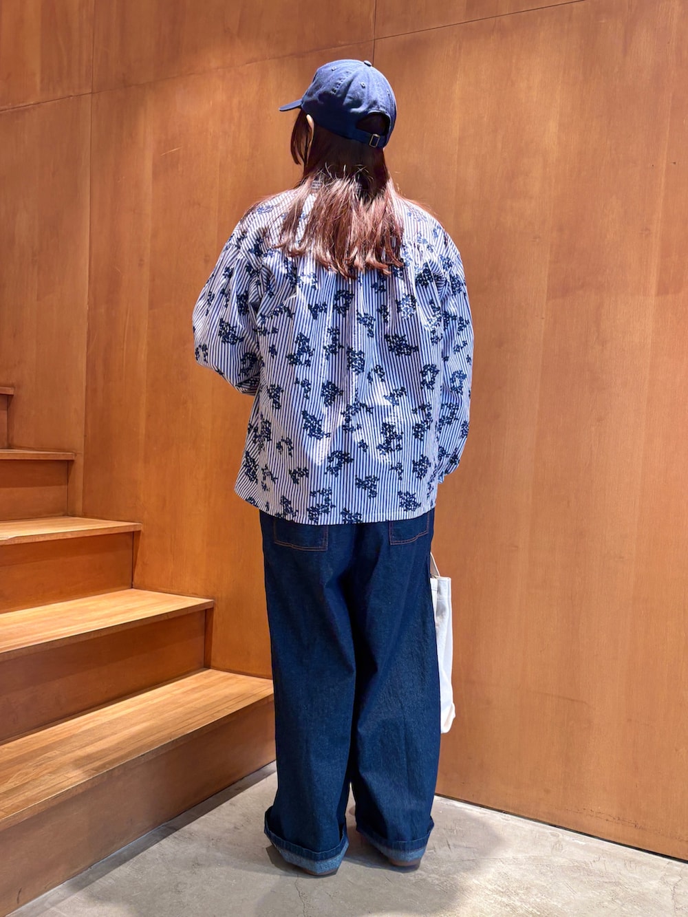 ホワイト系のTシャツ/カットソー、ブルー系のシャツ/ブラウス、ホワイト系のトートバッグを着用したレディースの春コーディネートの2枚目の写真