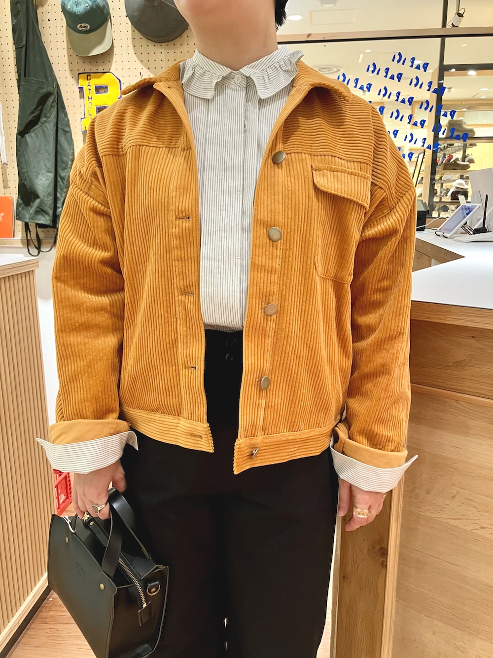 オレンジ系のブルゾン、ベージュ系のシャツ/ブラウス、ブラック系のその他パンツを着用したレディースの秋コーディネートの4枚目の写真