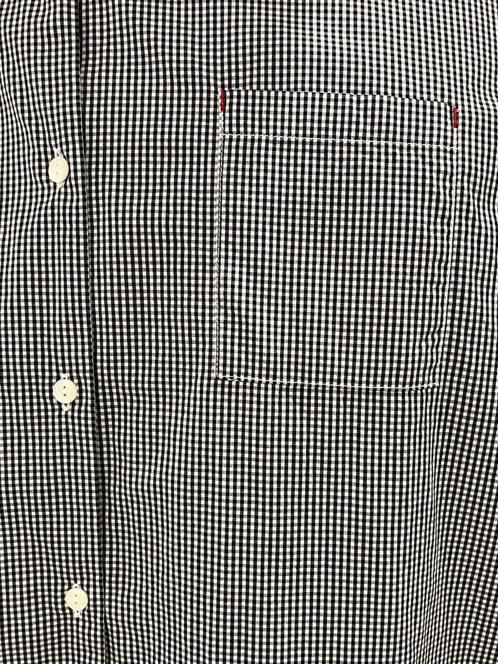 ブラック系のシャツワンピース、ブルー系のデニムパンツを着用したレディースの夏コーディネートの5枚目の写真