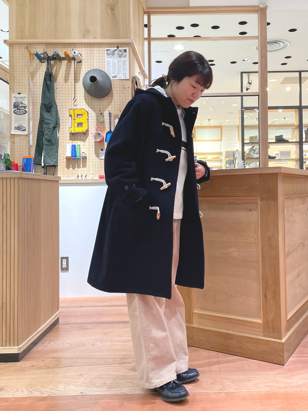 ブラック系のショルダーバッグ、ブルー系のダッフルコート、ベージュ系のその他パンツを着用したレディースの冬コーディネートの2枚目の写真