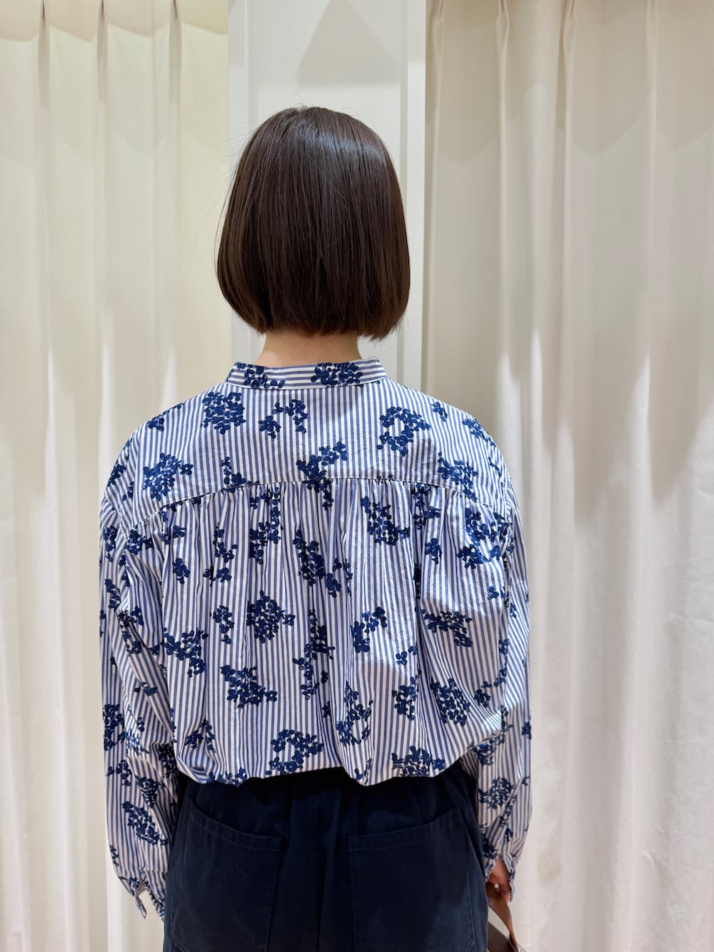 ブルー系のシャツ/ブラウス、ブルー系のチノパンツ、ブラウン系のショルダーバッグを着用したレディースの春コーディネートの5枚目の写真