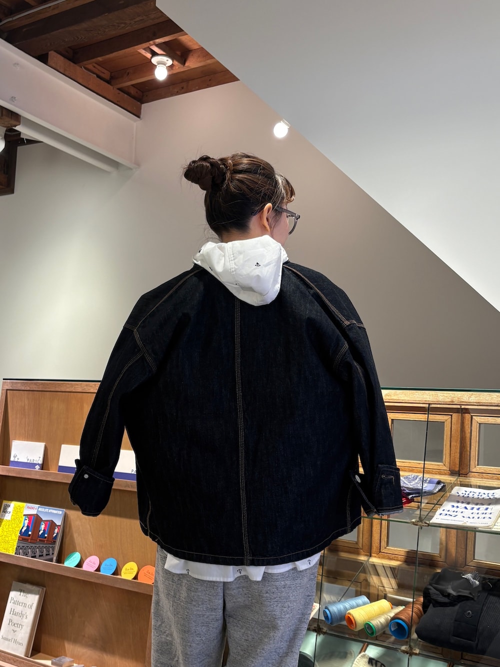 ホワイト系のシャツ/ブラウス、オレンジ系のカーディガン/ボレロ、グレー系のスウェットパンツを着用したレディースの冬コーディネートの5枚目の写真