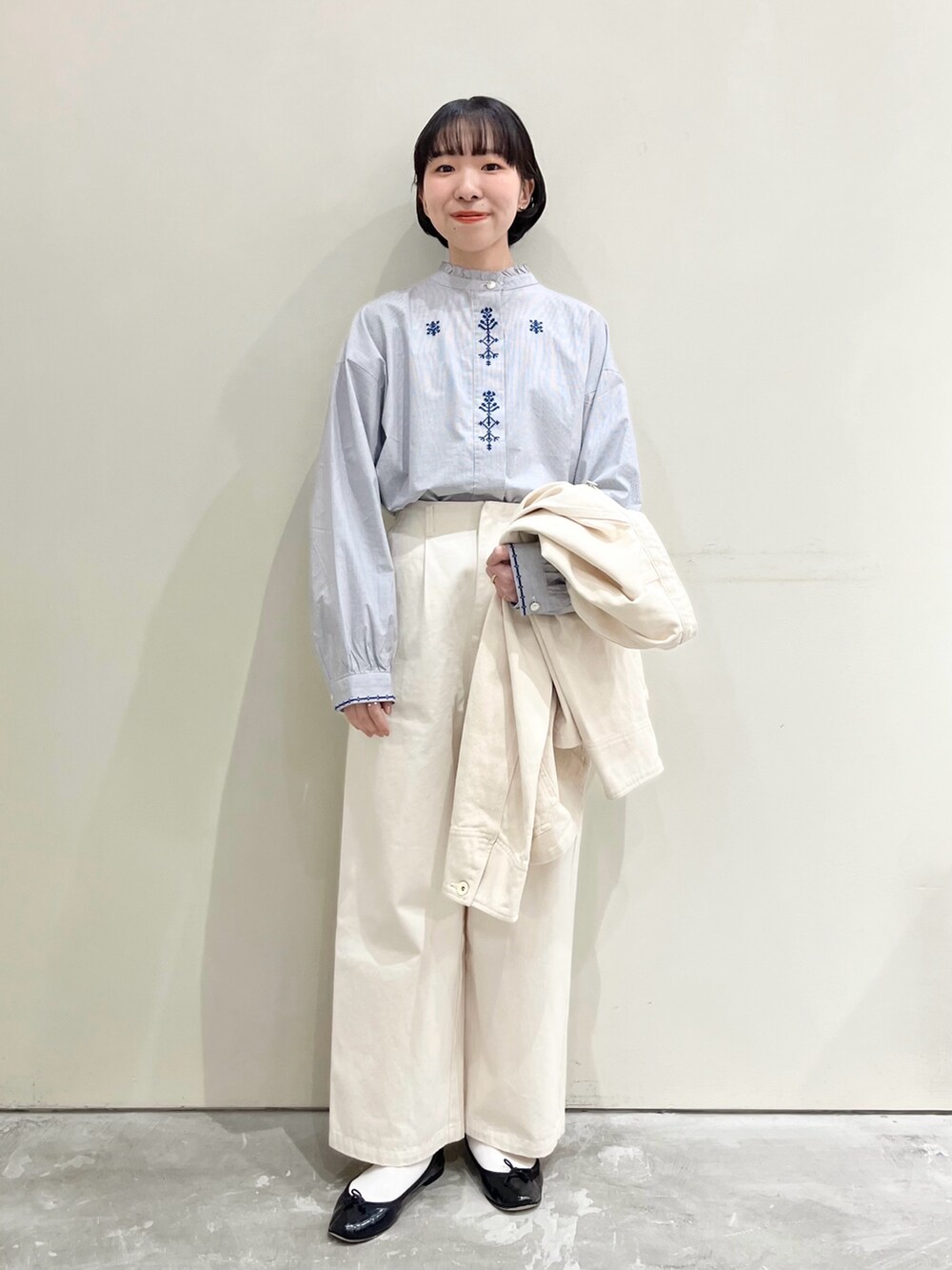 ブルー系のシャツ/ブラウス、ホワイト系のチノパンツ、ホワイト系のカバーオールを着用したレディースの冬コーディネートの2枚目の写真