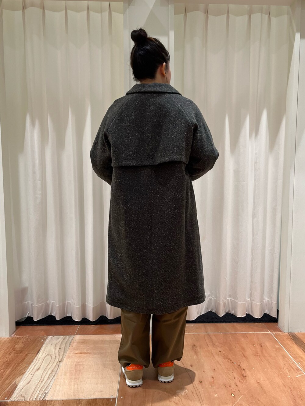 イエロー系のニット/セーター、ブラウン系のその他パンツ、グリーン系のステンカラーコートを着用したレディースの冬コーディネートの3枚目の写真