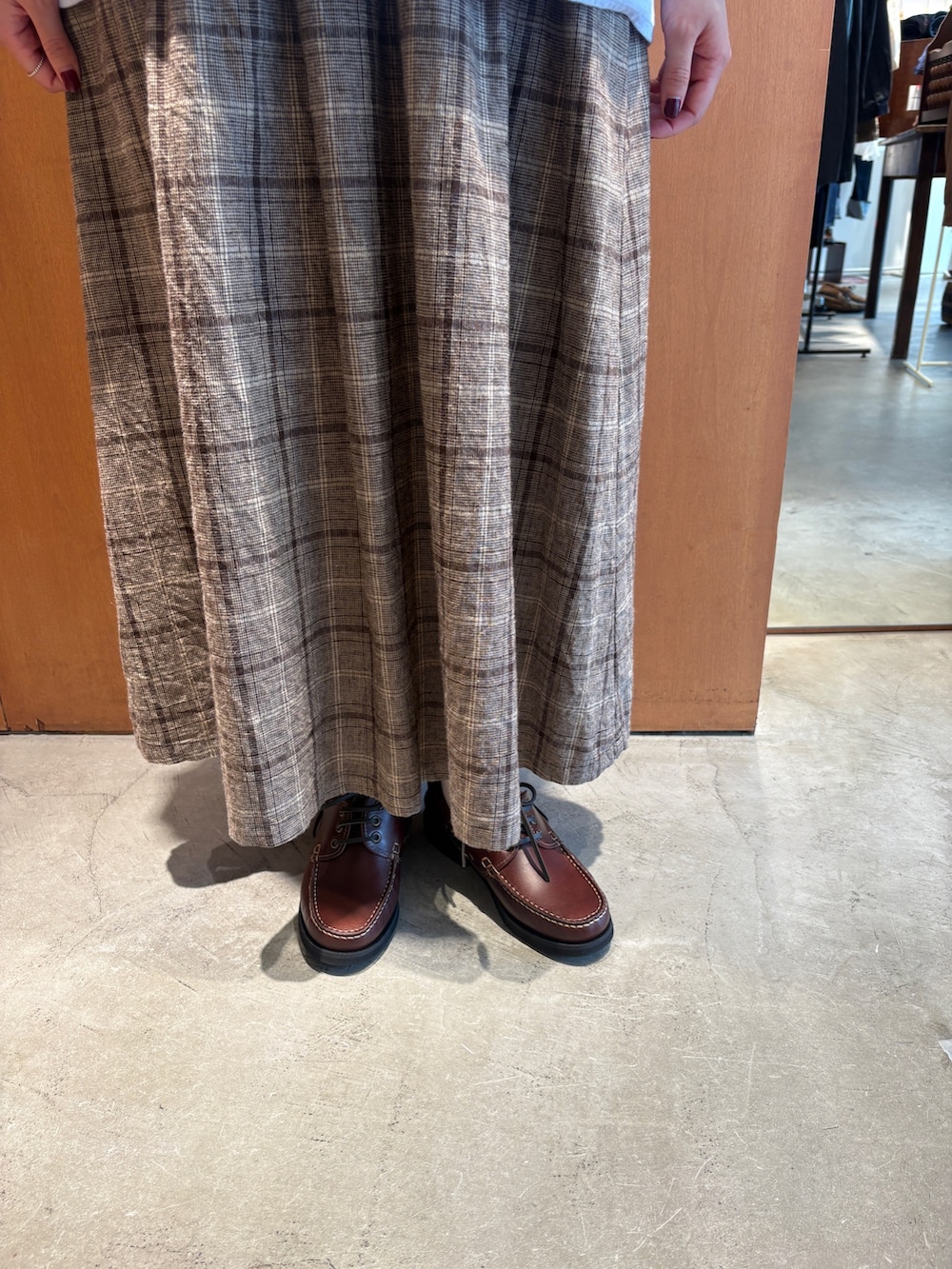 ブルー系のシャツ/ブラウス、ブラウン系のスカート、ブラウン系のモカシン/デッキシューズを着用したレディースの秋コーディネートの7枚目の写真