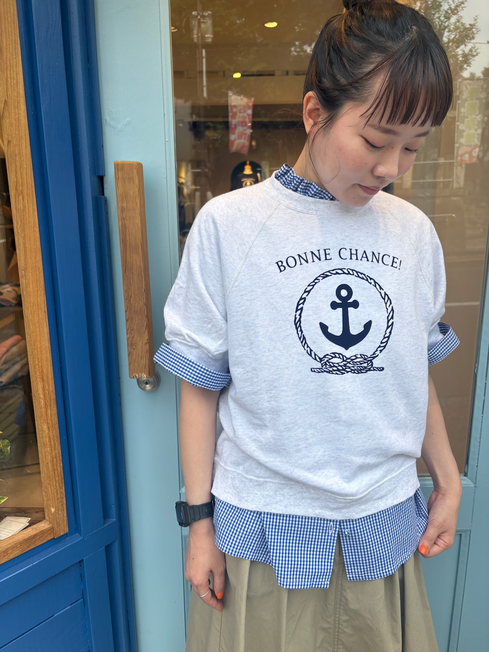 ブルー系のシャツ/ブラウス、ホワイト系のTシャツ/カットソー、ベージュ系のスカートを着用したレディースの夏コーディネートの2枚目の写真