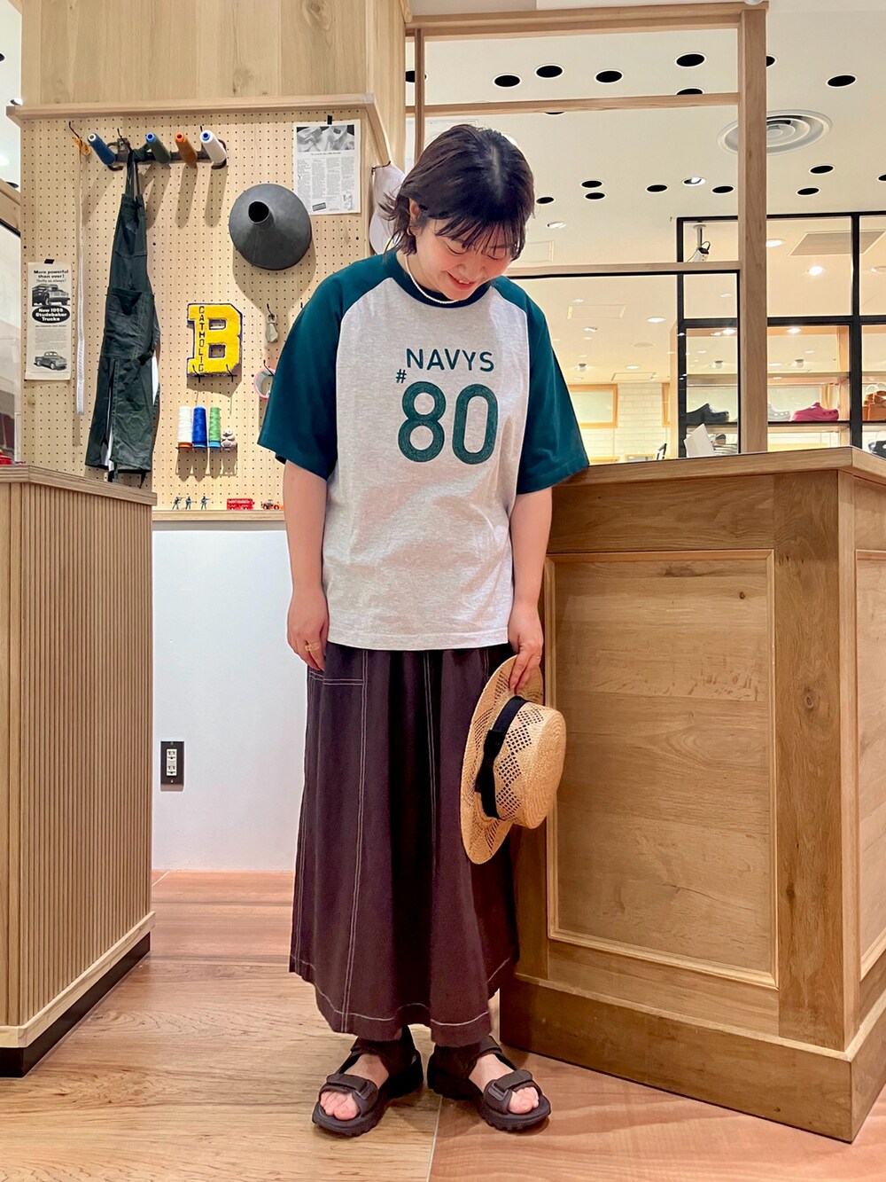 グリーン系のTシャツ/カットソー、ブラウン系のスカートを着用したレディースの夏コーディネートの3枚目の写真