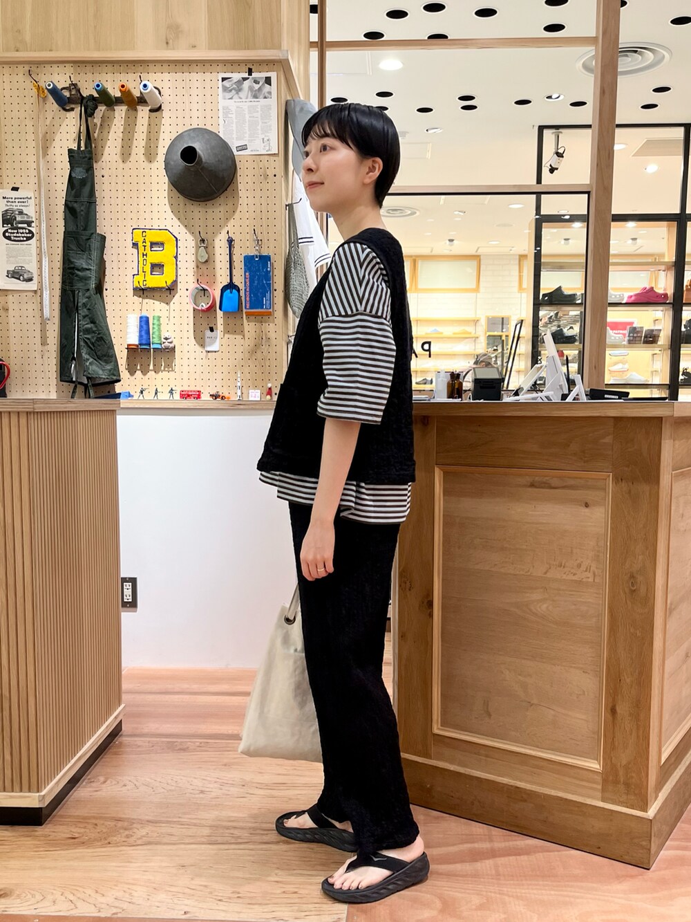 ブラック系のベスト、グリーン系のTシャツ/カットソー、ブラック系のその他パンツを着用したレディースの夏コーディネートの2枚目の写真