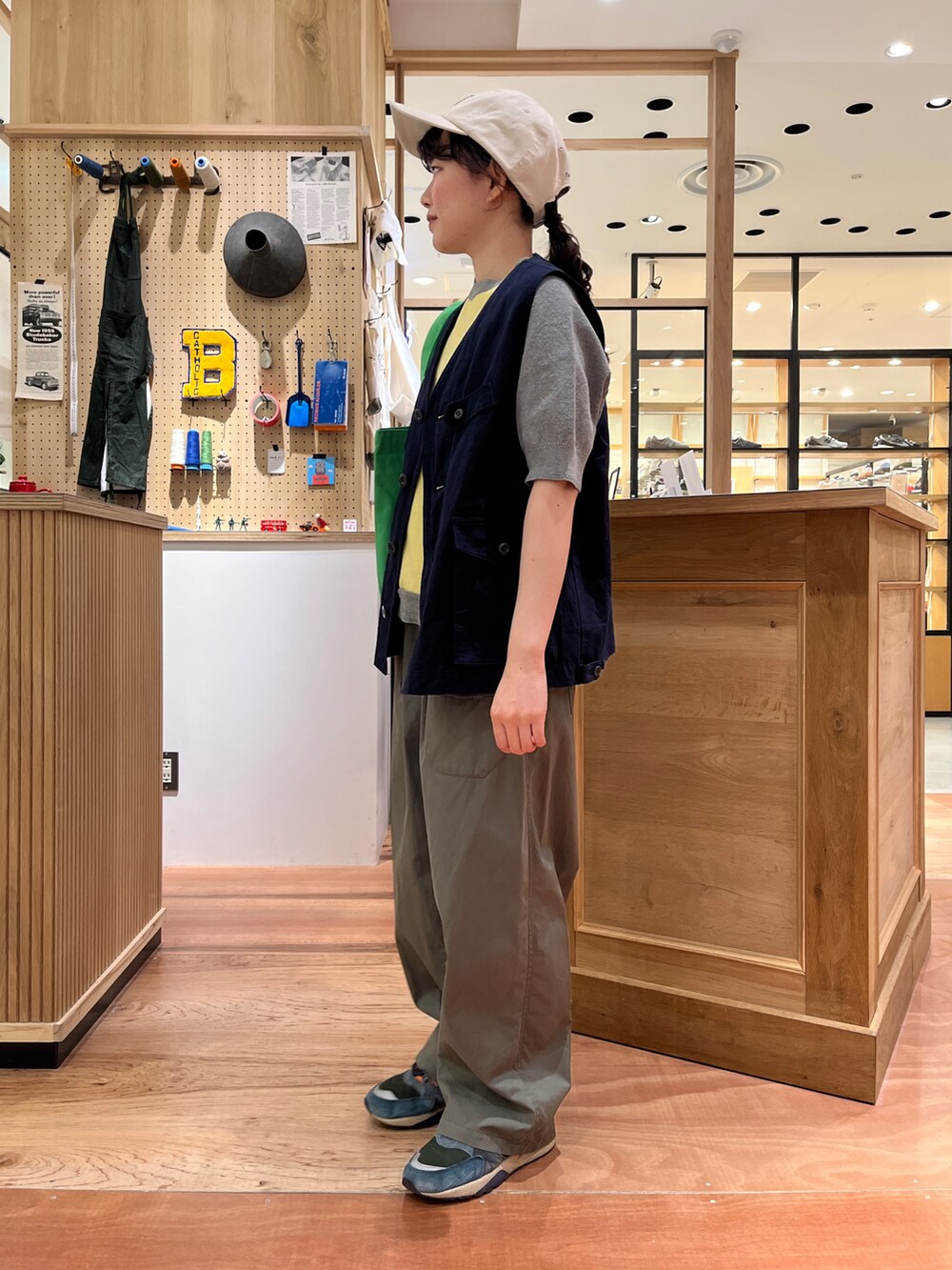 イエロー系のTシャツ/カットソー、ブルー系のベスト、グリーン系のその他パンツを着用したレディースの春コーディネートの2枚目の写真