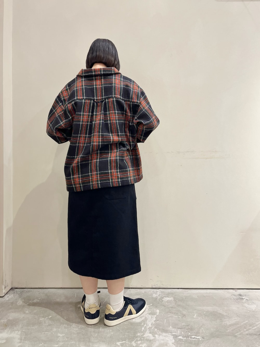 ブルー系のブルゾン、ブルー系のスカート、ホワイト系のTシャツ/カットソーを着用したレディースの秋コーディネートの2枚目の写真