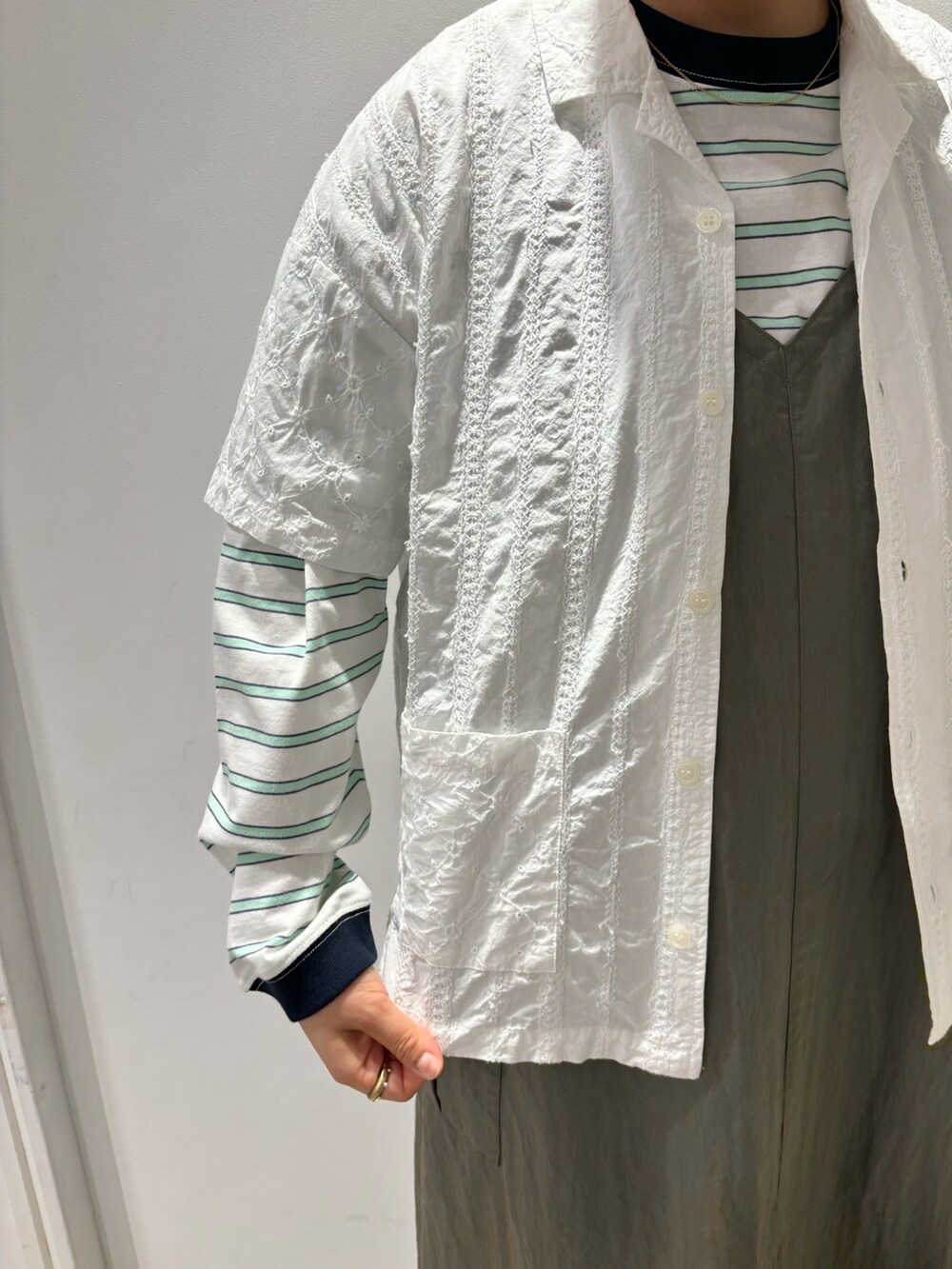 ホワイト系のシャツ/ブラウス、ホワイト系のTシャツ/カットソー、グリーン系のワンピースを着用したレディースの春コーディネートの3枚目の写真