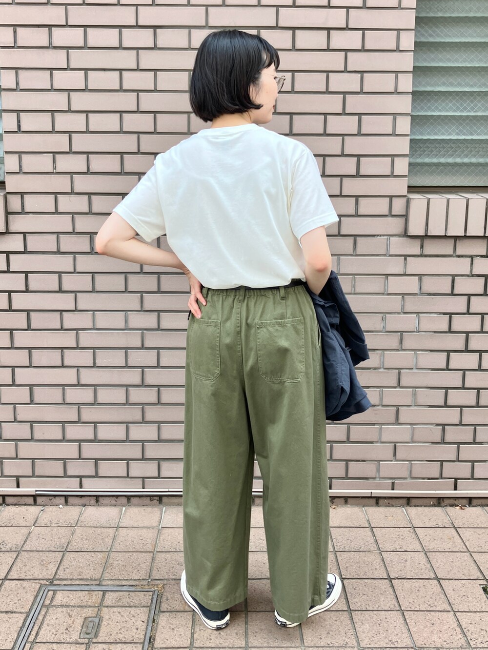 ホワイト系のTシャツ/カットソー、グリーン系のチノパンツ、ブラック系のベルトを着用したレディースの夏コーディネートの3枚目の写真
