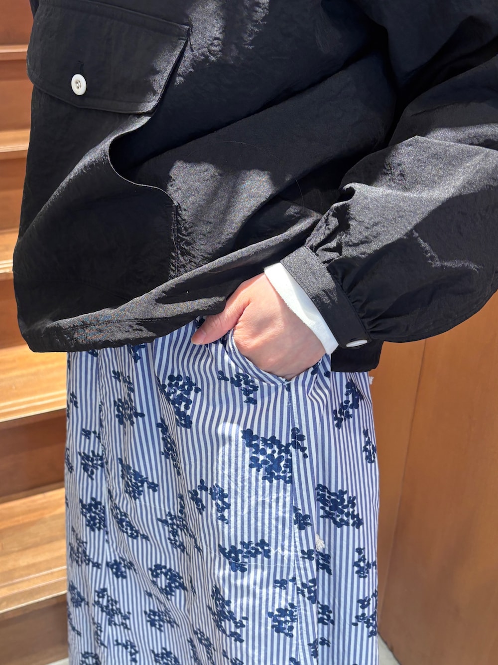 ホワイト系のTシャツ/カットソー、ブラック系のその他アウター、ブルー系のスカートを着用したレディースの春コーディネートの7枚目の写真