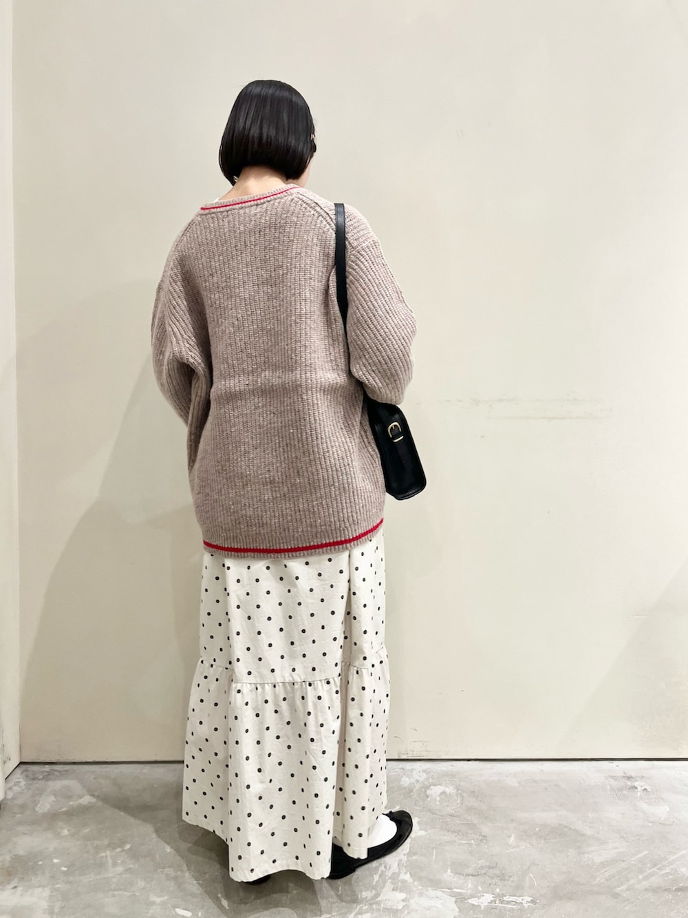 ホワイト系のTシャツ/カットソー、ブラック系のショルダーバッグ、ホワイト系のスカートを着用したレディースの冬コーディネートの3枚目の写真