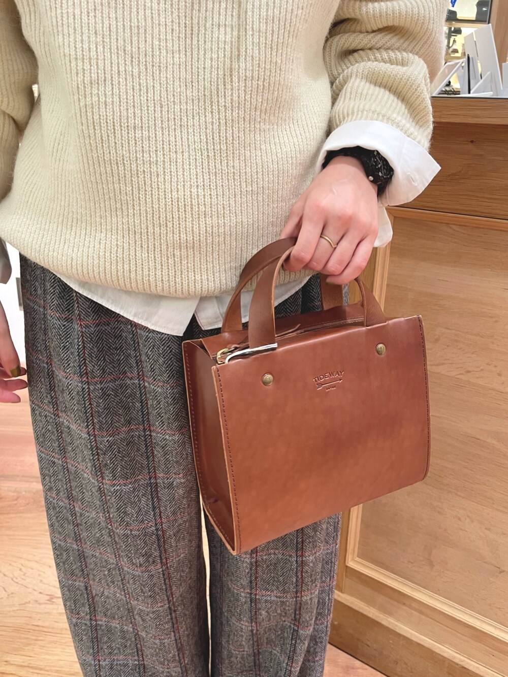 ホワイト系のシャツ/ブラウス、ホワイト系のニット/セーター、ブラウン系のショルダーバッグを着用したレディースの秋コーディネートの4枚目の写真