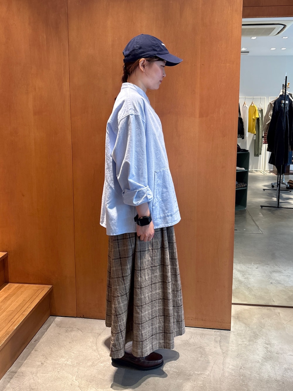 ブルー系のシャツ/ブラウス、ブラウン系のスカート、ブラウン系のモカシン/デッキシューズを着用したレディースの秋コーディネートの2枚目の写真