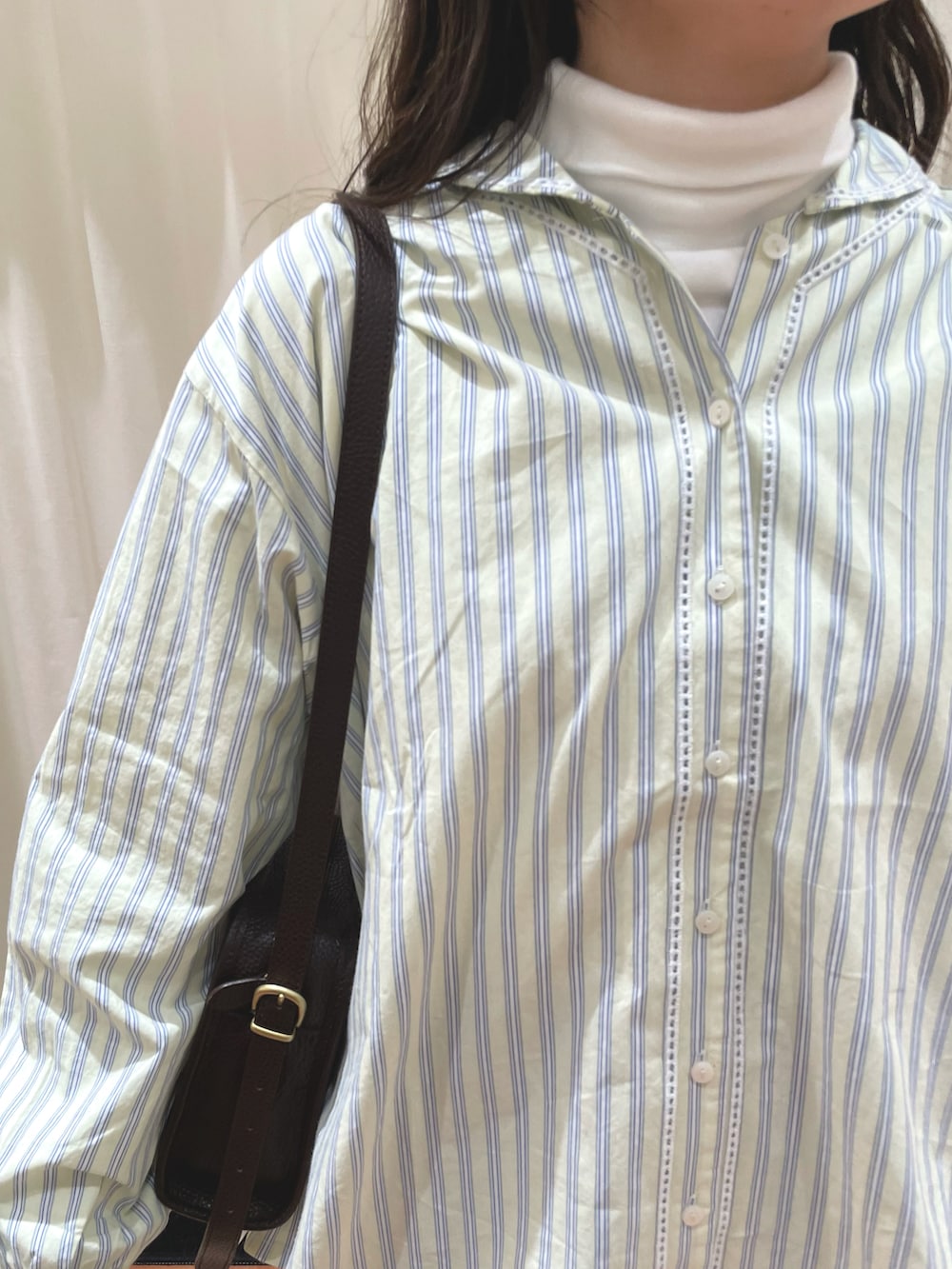 イエロー系のシャツ/ブラウス、グレー系のスカート、ホワイト系のTシャツ/カットソーを着用したレディースの冬コーディネートの4枚目の写真