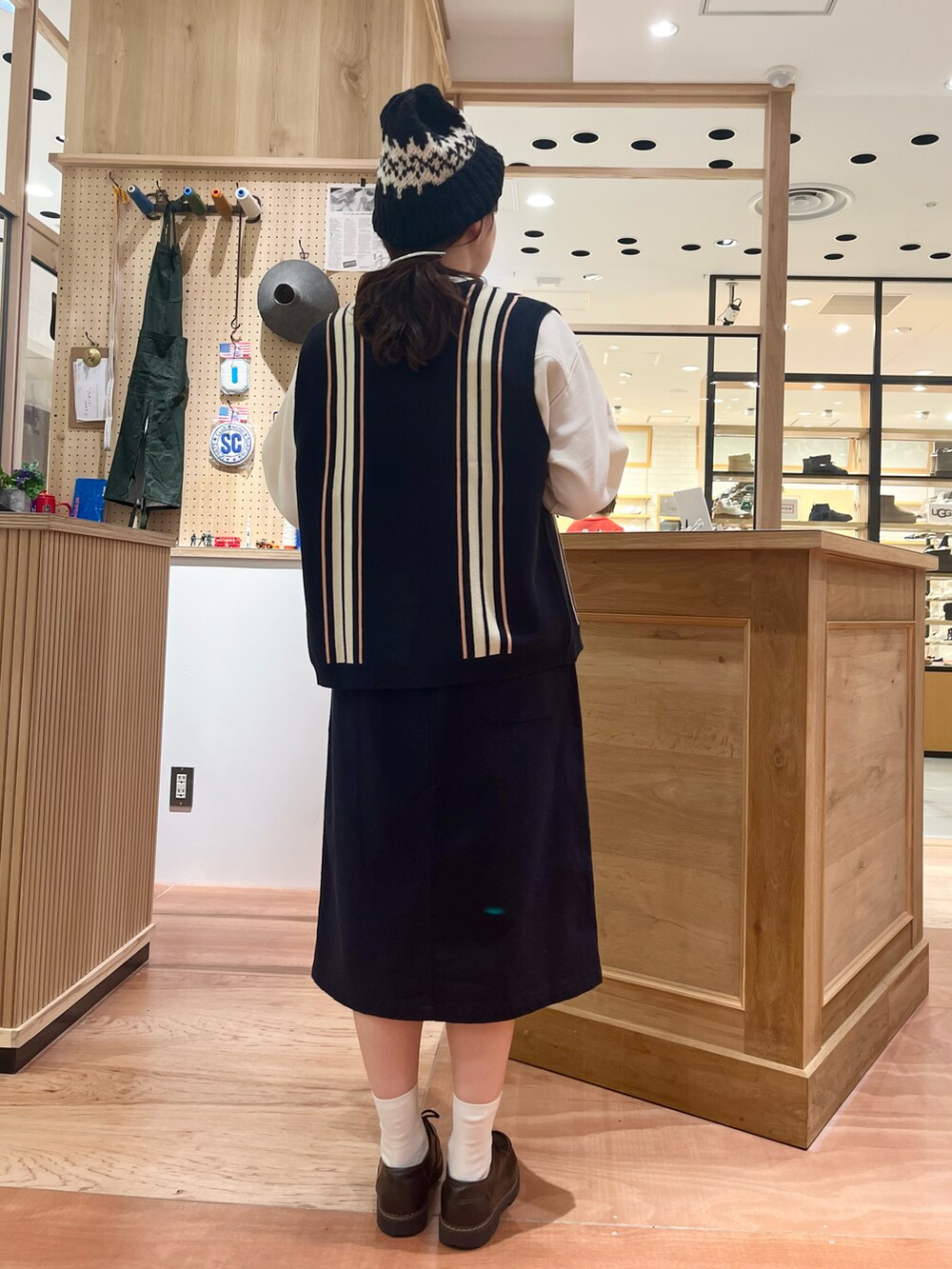 ホワイト系のシャツ/ブラウス、ブルー系のベスト、ブルー系のスカートを着用したレディースの秋コーディネートの3枚目の写真