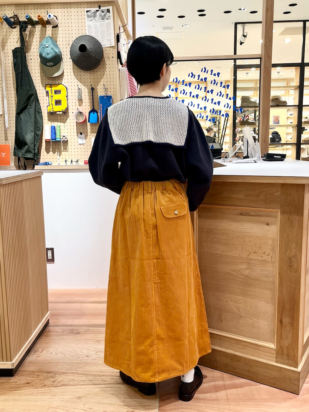 ブルー系のスウェット、イエロー系のスカート、ホワイト系の付け襟を着用したレディースの秋コーディネートの3枚目の写真