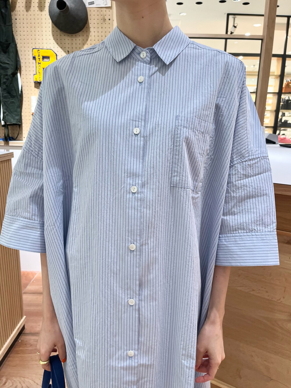 ブルー系のシャツワンピース、ブルー系のトートバッグを着用したレディースの夏コーディネートの5枚目の写真