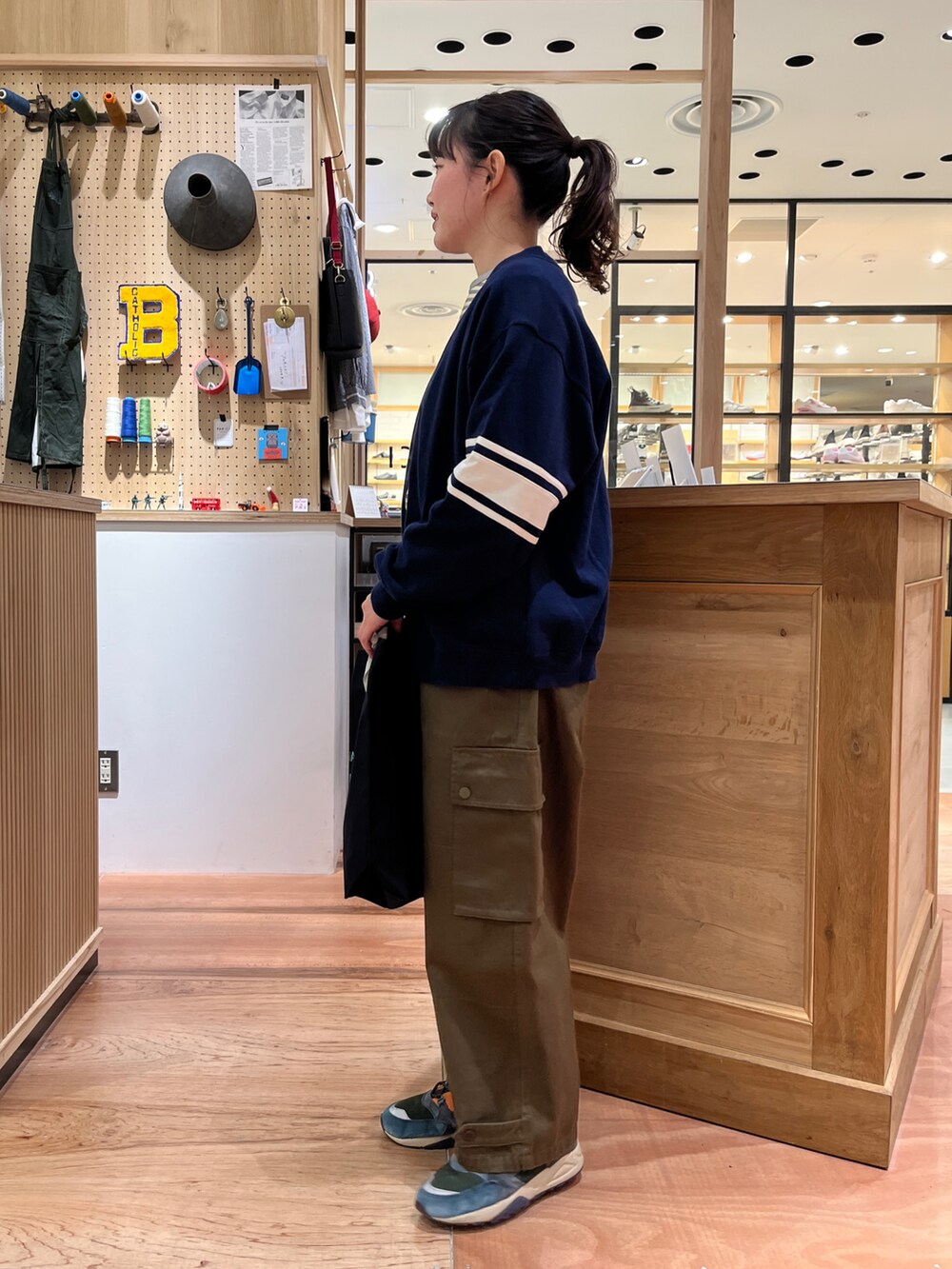 イエロー系のTシャツ/カットソー、ブルー系のカーディガン/ボレロ、グリーン系のカーゴパンツを着用したレディースの冬コーディネートの2枚目の写真