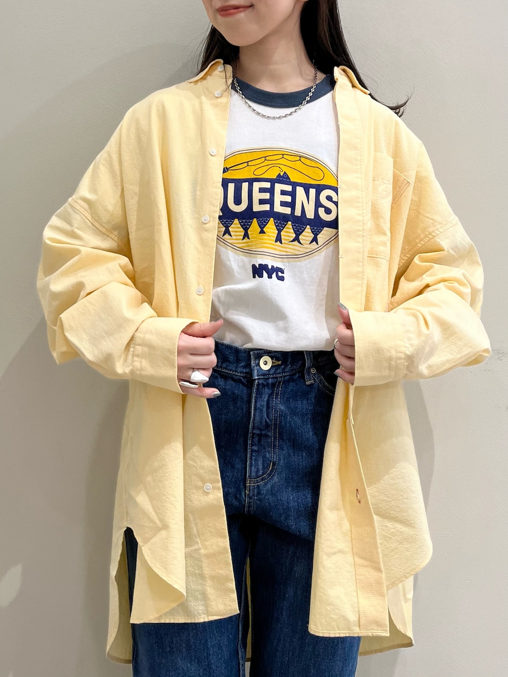 ブルー系のTシャツ/カットソー、イエロー系のシャツ/ブラウス、ブルー系のデニムパンツを着用したレディースの春コーディネートの4枚目の写真