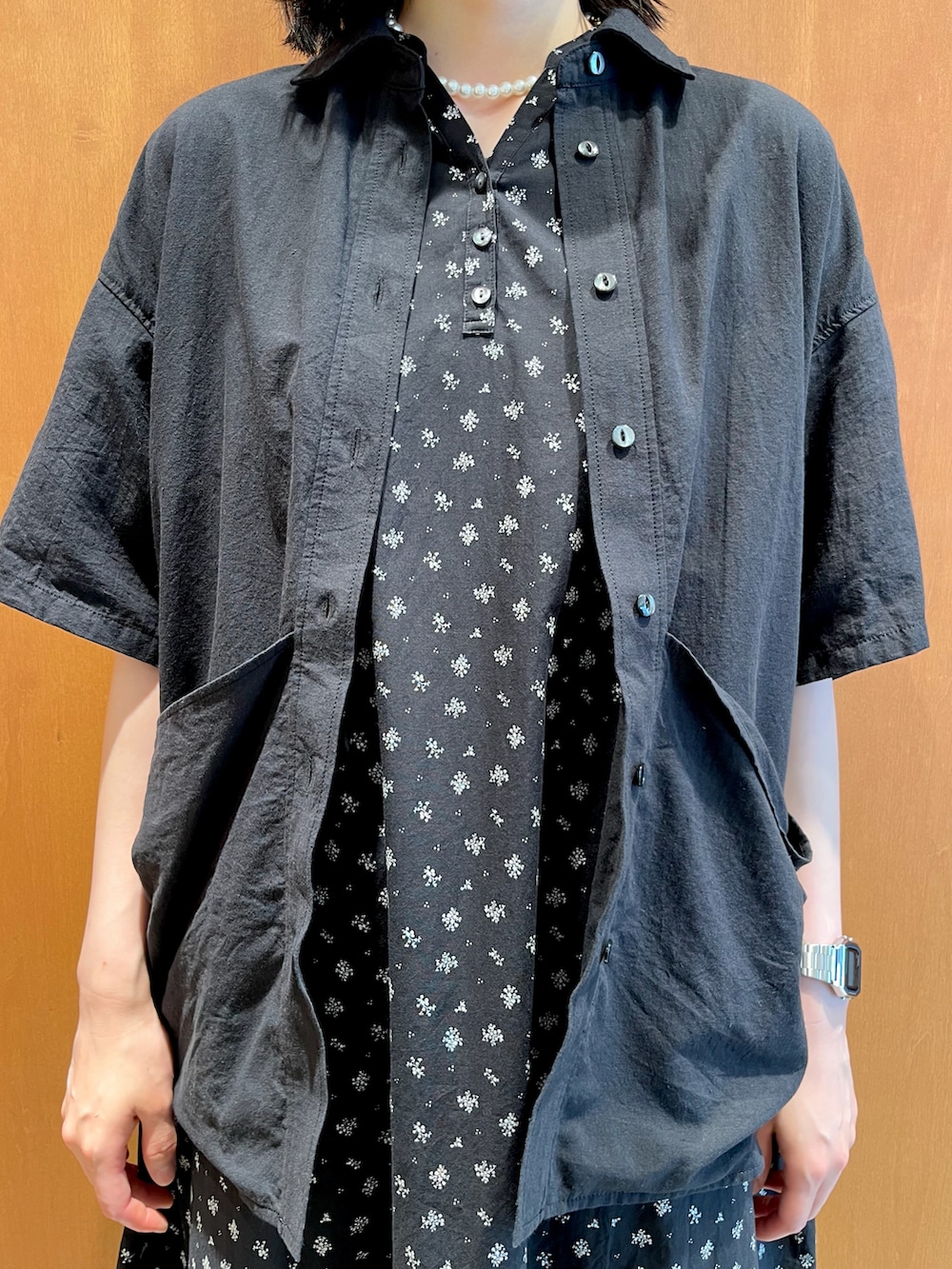 ブラック系のワンピース、ベージュ系のシャツ/ブラウスを着用したレディースの夏コーディネートの3枚目の写真