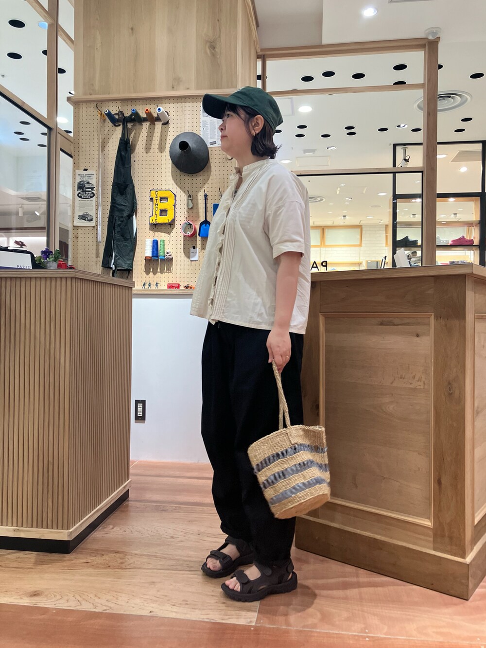 ホワイト系のシャツ/ブラウス、グレー系のかごバッグ、ブラック系のその他パンツを着用したレディースの夏コーディネートの2枚目の写真