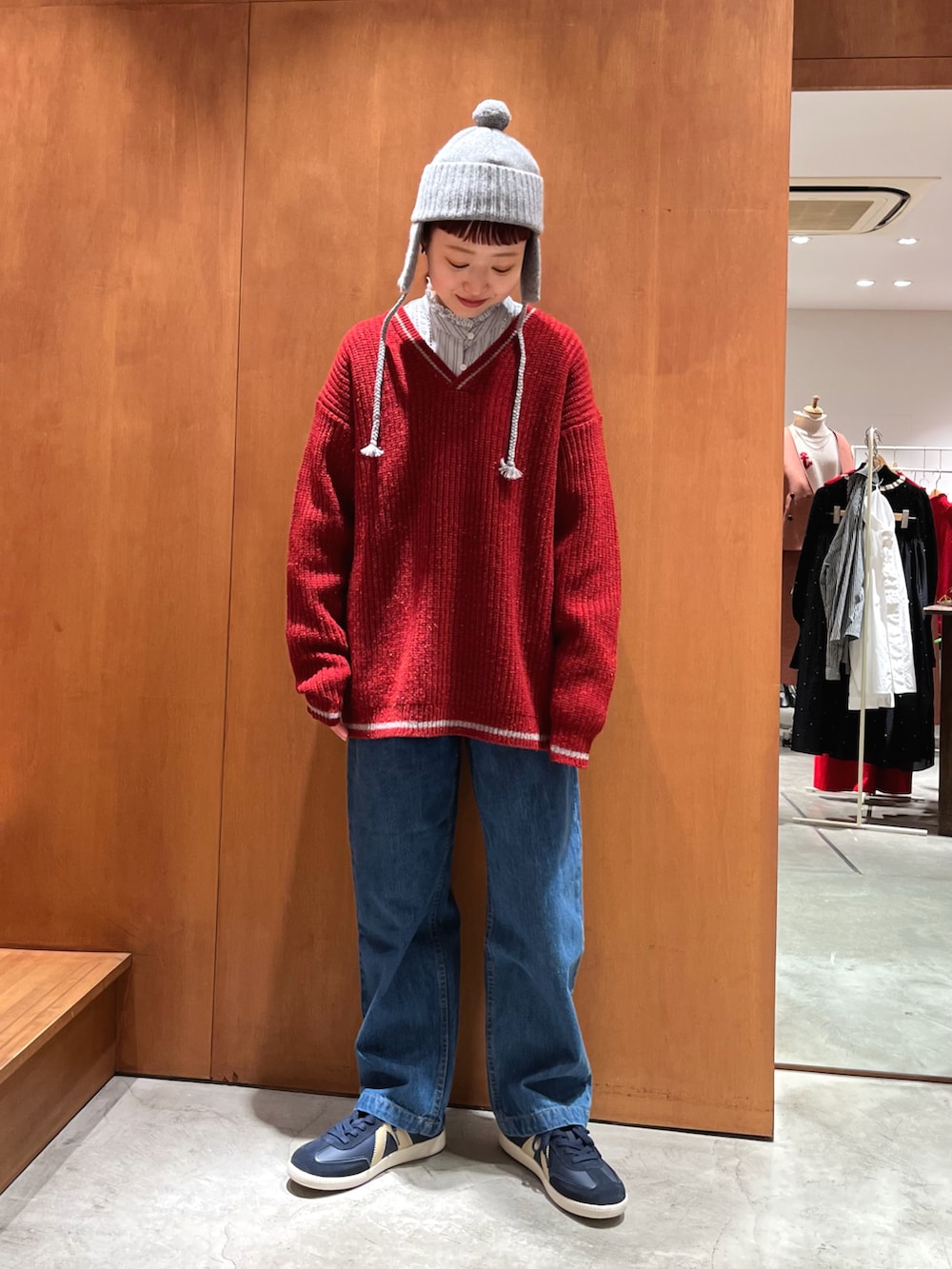 レッド系のニット/セーター、ブルー系のシャツ/ブラウスを着用したレディースの冬コーディネートの2枚目の写真