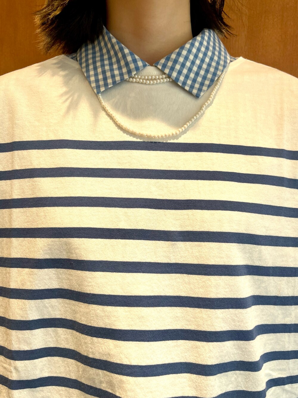 ブルー系のTシャツ/カットソー、ブルー系のシャツ/ブラウス、ベージュ系のチノパンツを着用したレディースの秋コーディネートの3枚目の写真