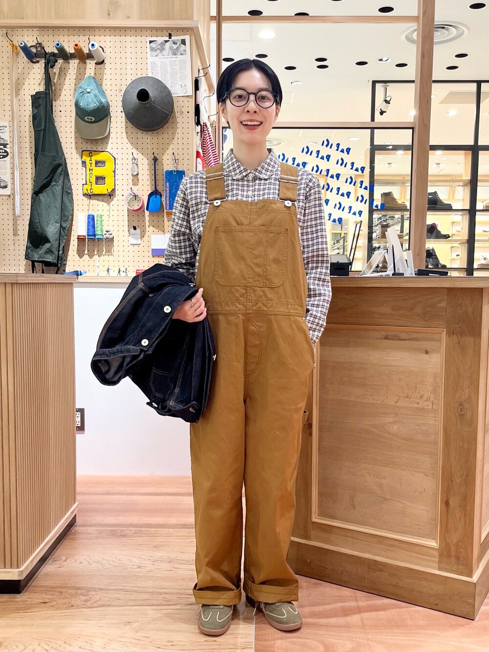 ブルー系のシャツ/ブラウス、ブルー系のカバーオール、ブラウン系のサロペット/オーバーオールを着用したレディースの秋コーディネートの3枚目の写真