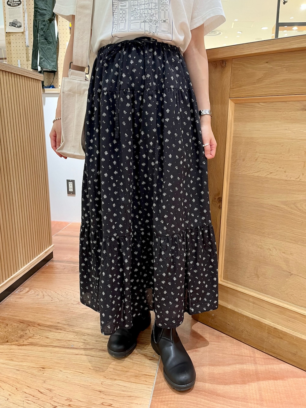 ホワイト系のTシャツ/カットソー、ホワイト系のショルダーバッグ、ブラック系のスカートを着用したレディースの夏コーディネートの5枚目の写真