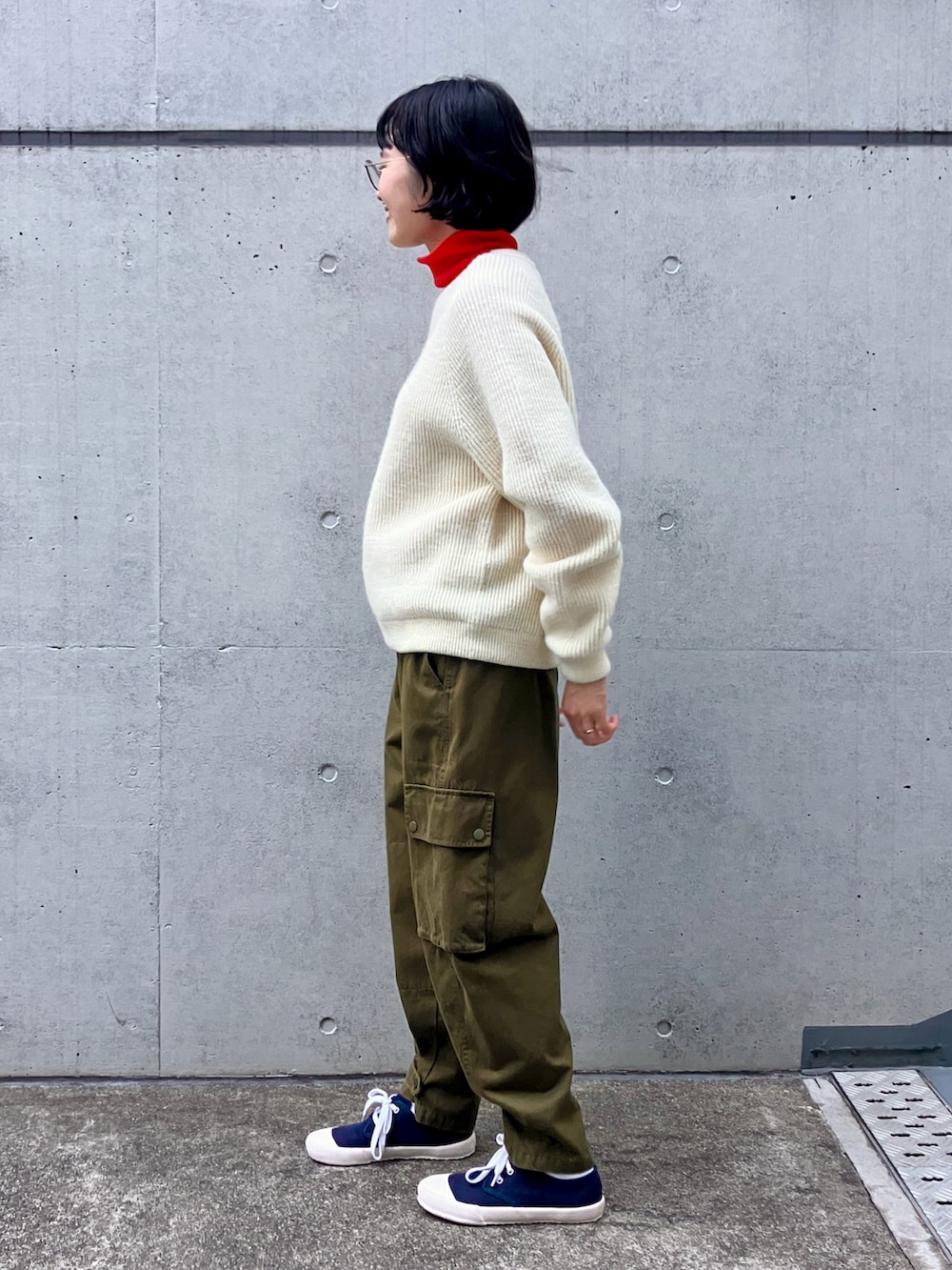 ホワイト系のニット/セーター、レッド系のTシャツ/カットソー、グリーン系のカーゴパンツを着用したレディースの秋コーディネートの2枚目の写真