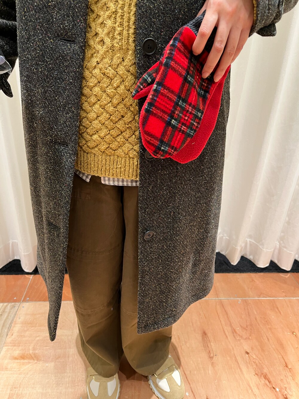 イエロー系のニット/セーター、ブラウン系のその他パンツ、グリーン系のステンカラーコートを着用したレディースの冬コーディネートの4枚目の写真