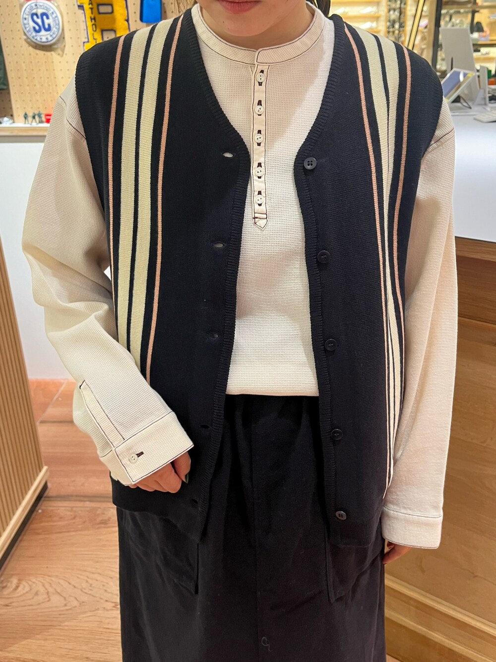 ホワイト系のシャツ/ブラウス、ブルー系のベスト、ブルー系のスカートを着用したレディースの秋コーディネートの4枚目の写真