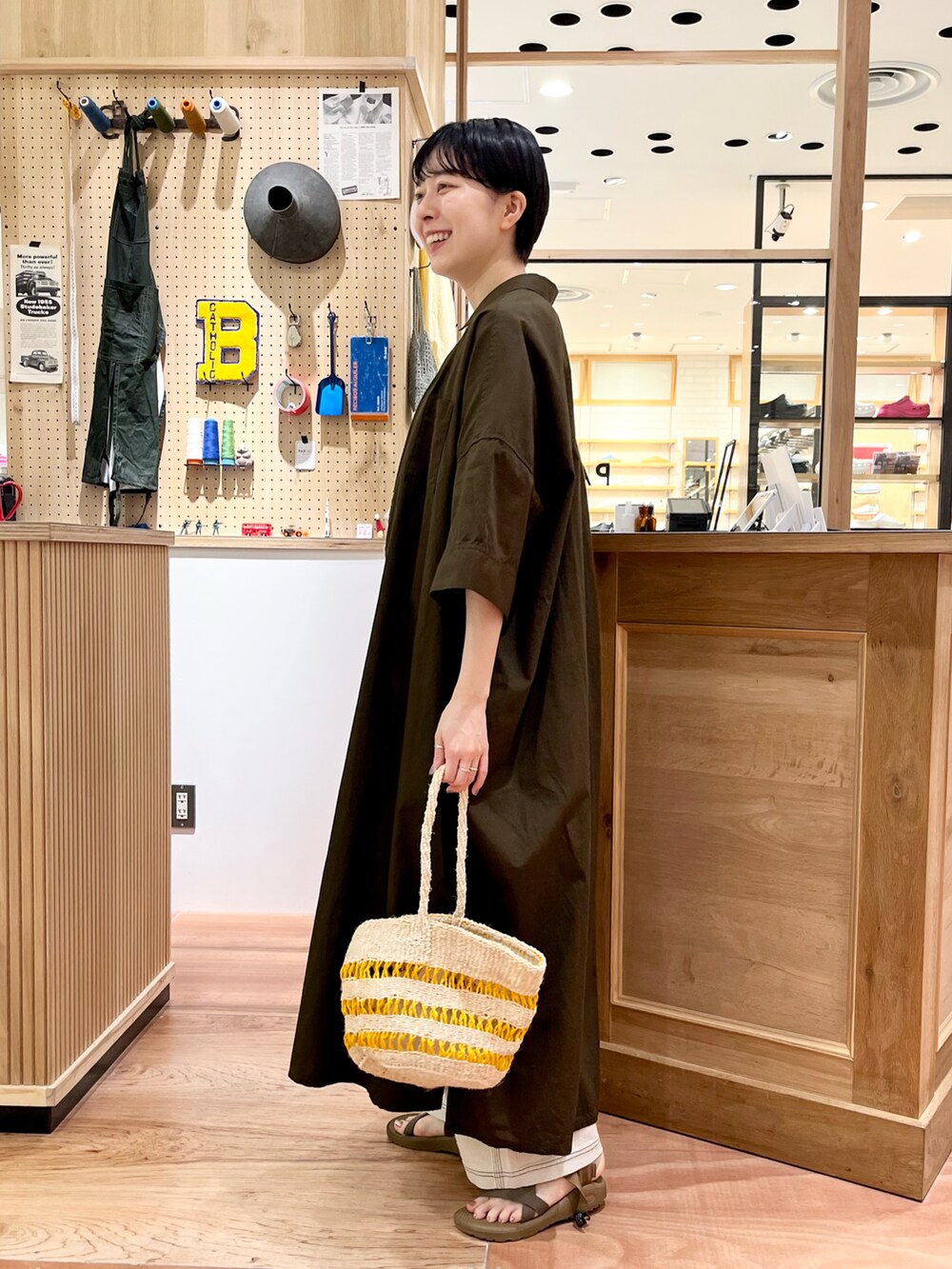 ブラウン系のTシャツ/カットソー、ブラウン系のシャツワンピース、ホワイト系のデニムパンツを着用したレディースの夏コーディネートの2枚目の写真