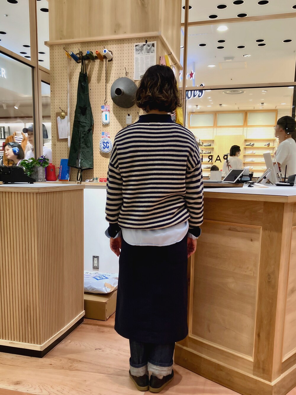 その他のニット/セーター、グリーン系のスカート、ブルー系のデニムパンツを着用したレディースの秋コーディネートの4枚目の写真