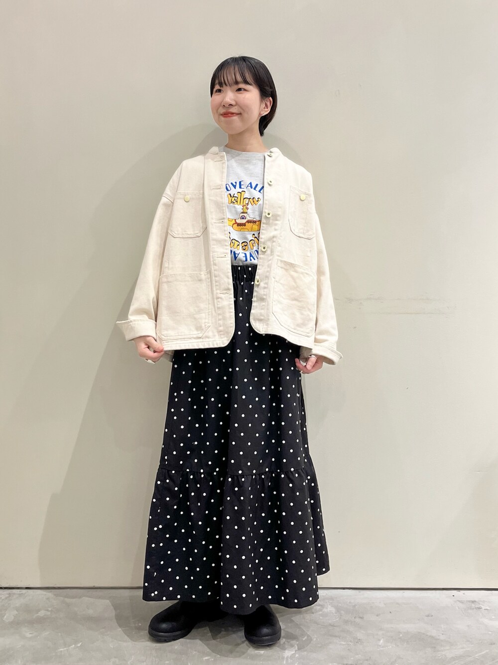 ホワイト系のカバーオール、ブラック系のスカート、グレー系のTシャツ/カットソーを着用したレディースの春コーディネートの2枚目の写真