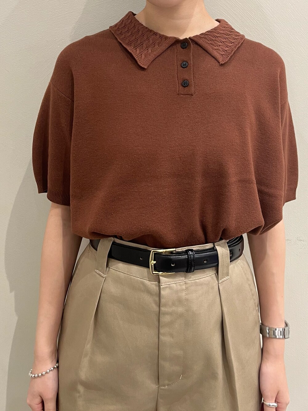 ブラウン系のポロシャツを着用したレディースの春コーディネートの4枚目の写真