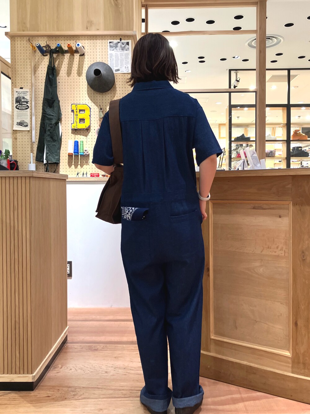 ブルー系のつなぎ/オールインワン、ブラウン系のショルダーバッグ、ホワイト系のタンクトップを着用したレディースの春コーディネートの2枚目の写真