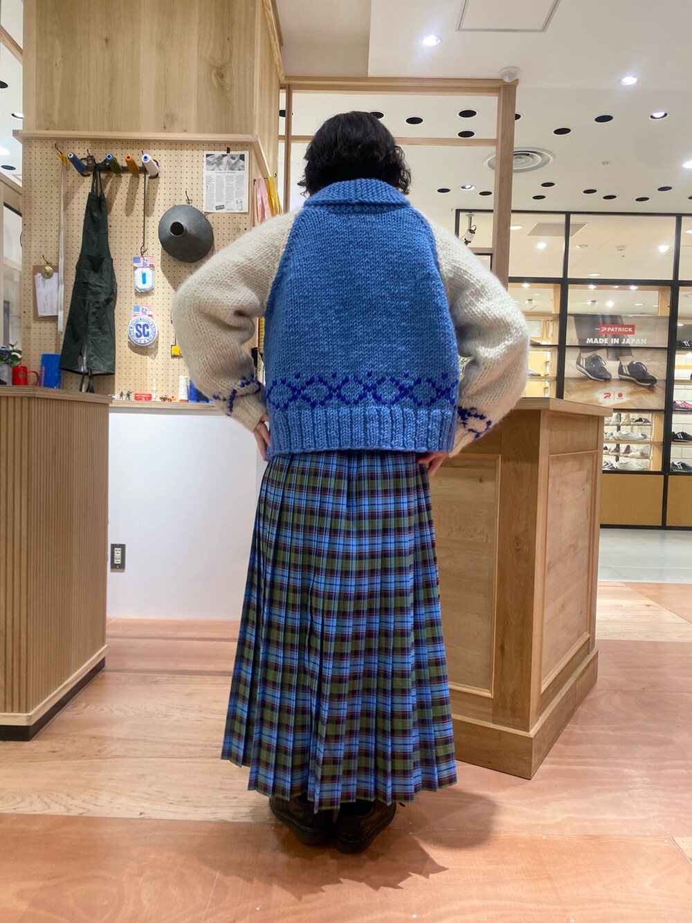 グリーン系のスカート、ホワイト系のTシャツ/カットソー、ブルー系のカーディガン/ボレロを着用したレディースの秋コーディネートの2枚目の写真