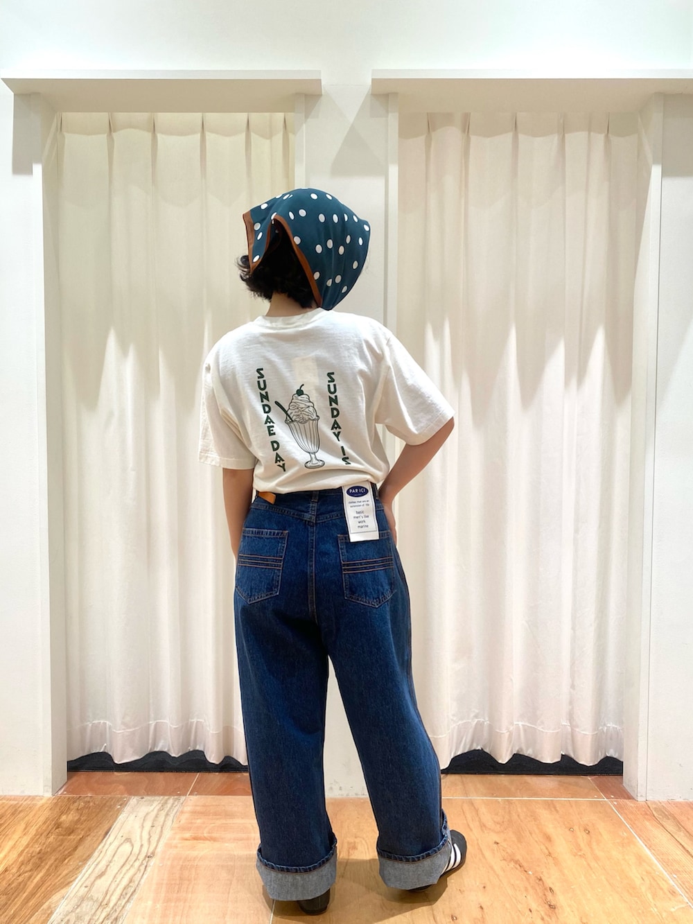 ブルー系のデニムパンツ、ホワイト系のTシャツ/カットソー、ブラウン系のベルトを着用したレディースの夏コーディネートの3枚目の写真