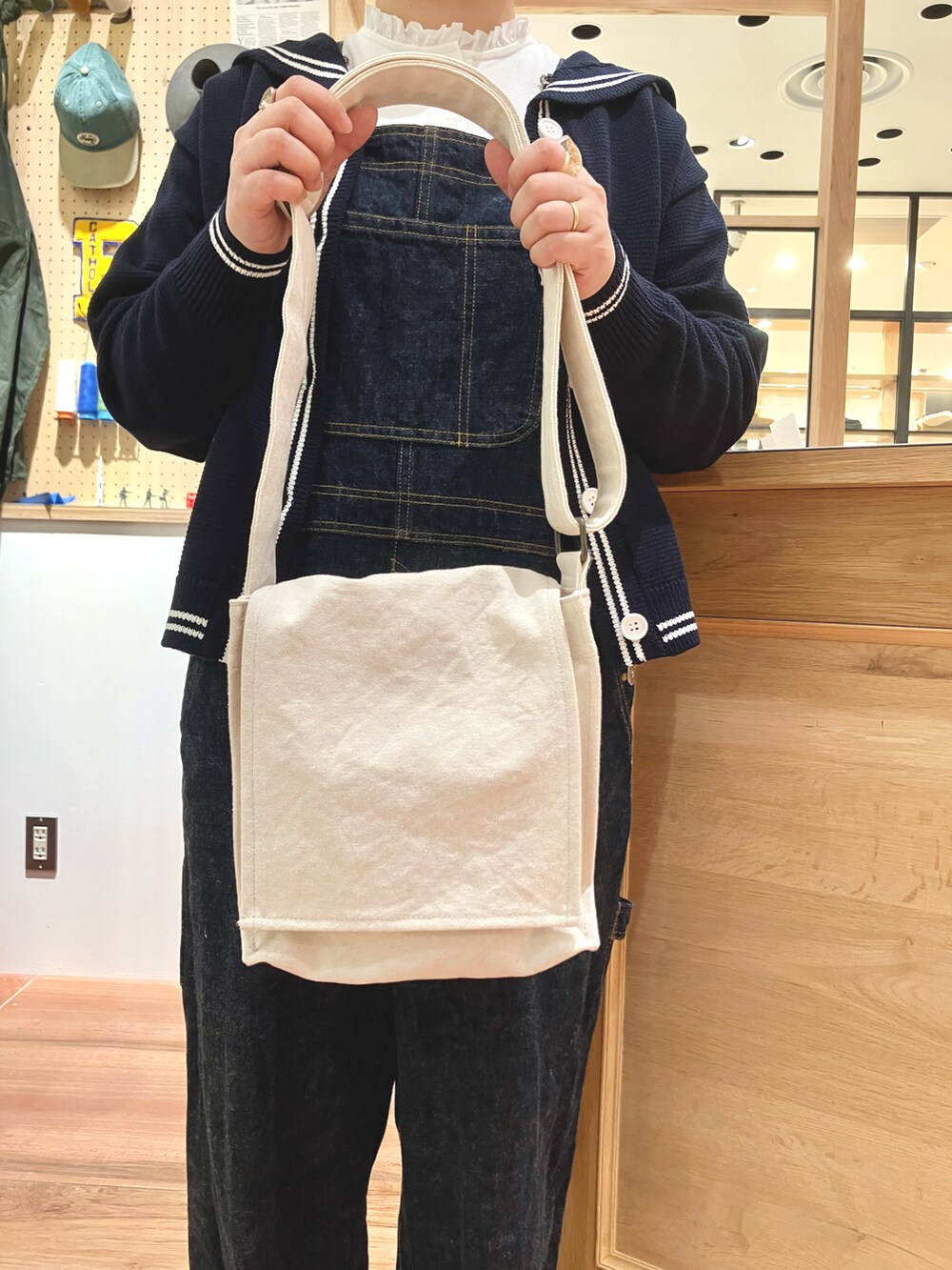 ブルー系のカーディガン/ボレロ、ホワイト系のTシャツ/カットソー、ブルー系のサロペット/オーバーオールを着用したレディースの秋コーディネートの3枚目の写真