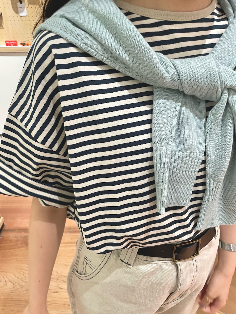 グリーン系のTシャツ/カットソー、ブルー系のカーディガン/ボレロ、ホワイト系のデニムパンツを着用したレディースの夏コーディネートの5枚目の写真