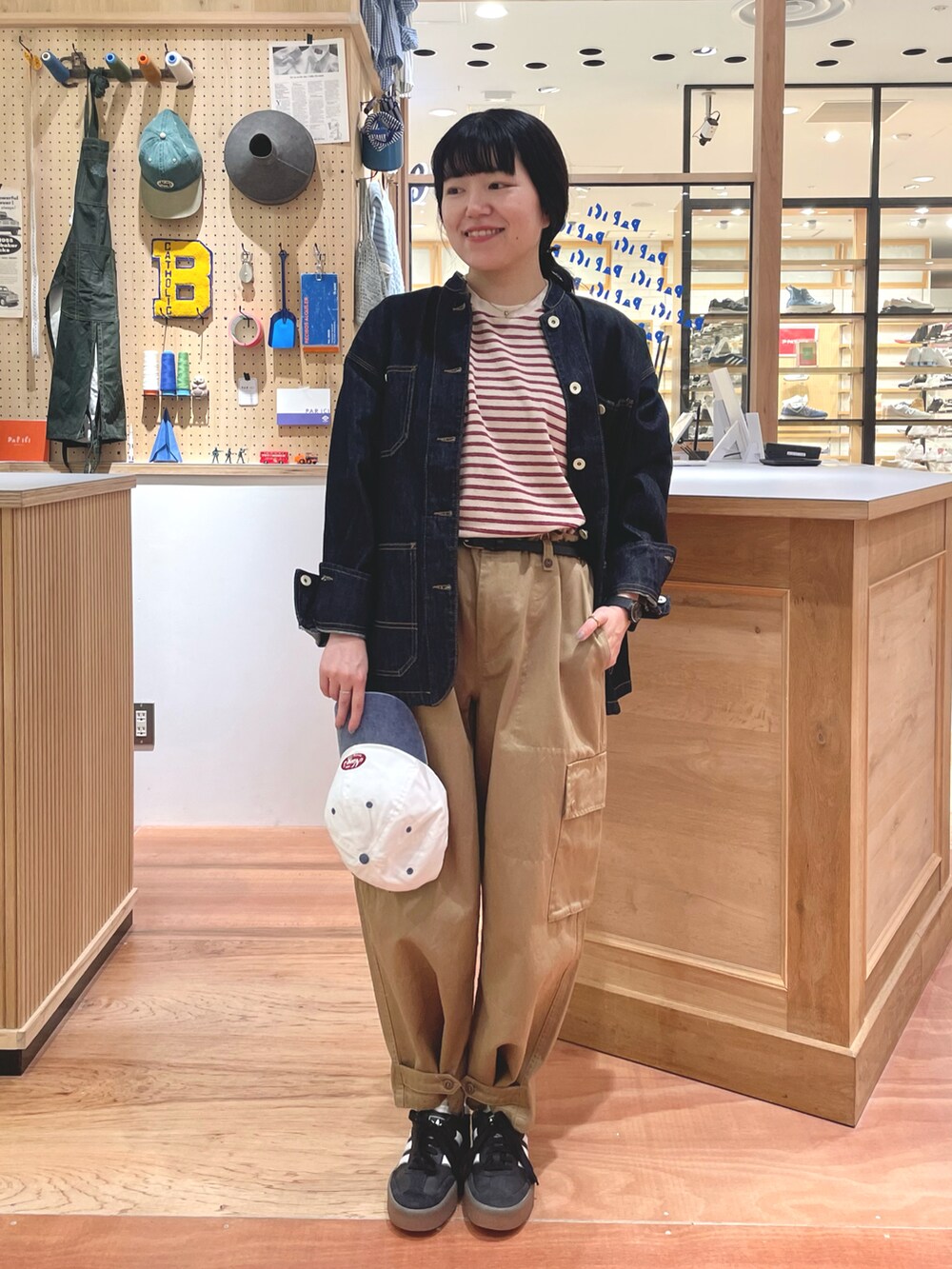 ベージュ系のカーゴパンツ、ベージュ系のTシャツ/カットソー、ブルー系のカバーオールを着用したレディースの秋コーディネートの4枚目の写真