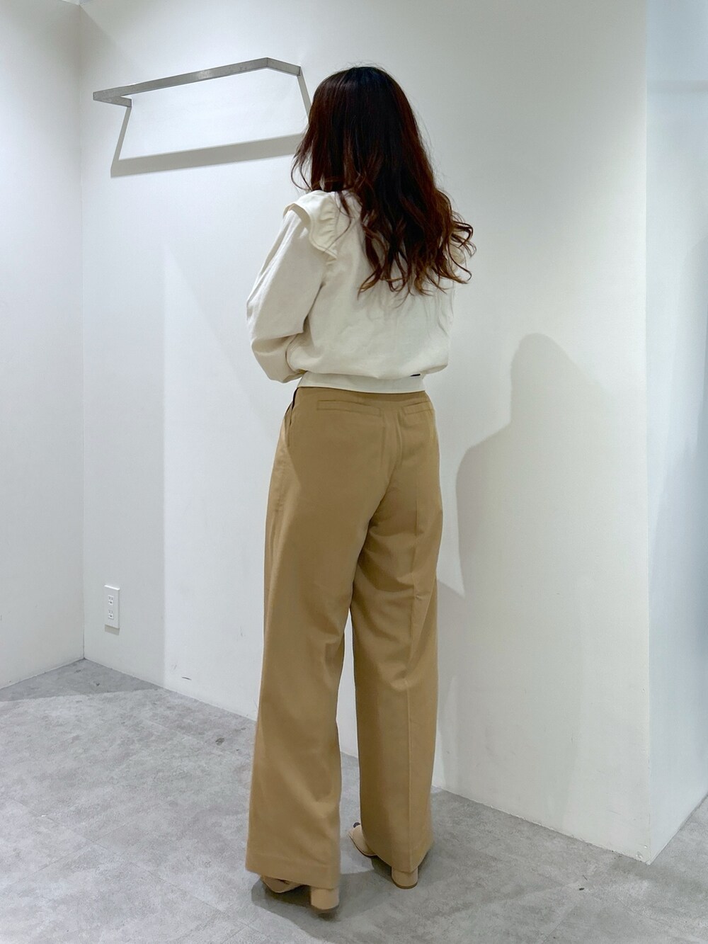 ホワイト系のシャツ/ブラウス、ホワイト系のトートバッグ、ベージュ系のスラックスを着用したレディースの春コーディネートの2枚目の写真