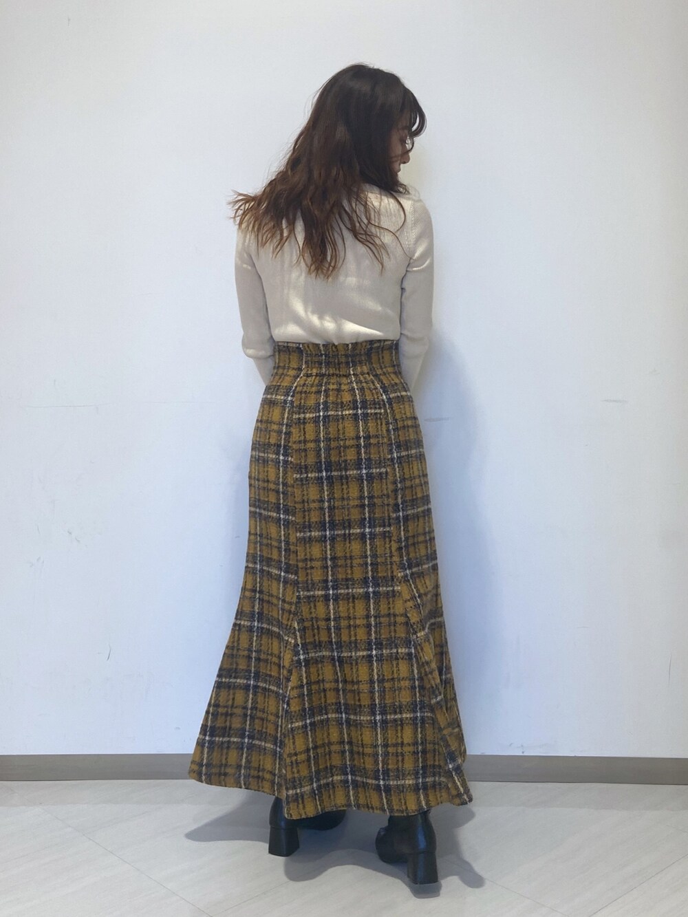 ホワイト系のニット/セーター、イエロー系のスカート、ブラック系のショルダーバッグを着用したレディースの秋コーディネートの5枚目の写真