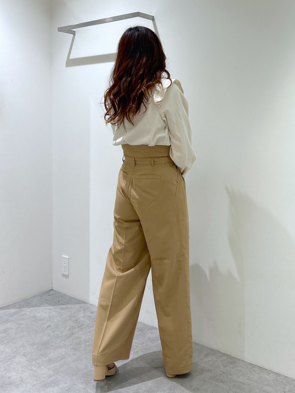 ホワイト系のシャツ/ブラウス、ホワイト系のトートバッグ、ベージュ系のスラックスを着用したレディースの春コーディネートの3枚目の写真