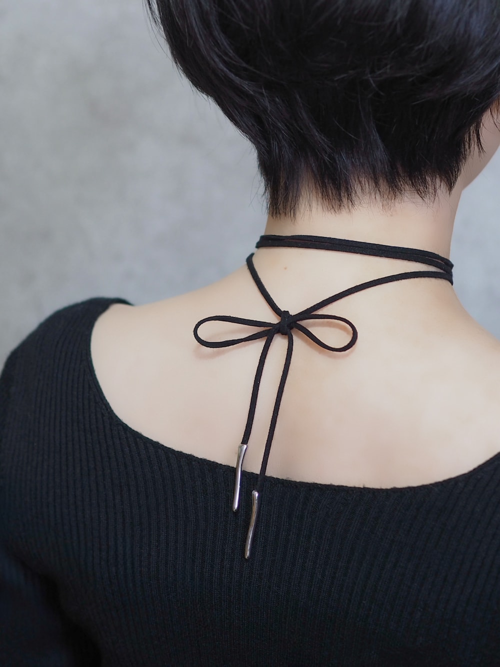 ブラック系のパンプス、ブラック系のスカート、ピンク系のテーラードジャケットを着用したレディースの春コーディネートの3枚目の写真