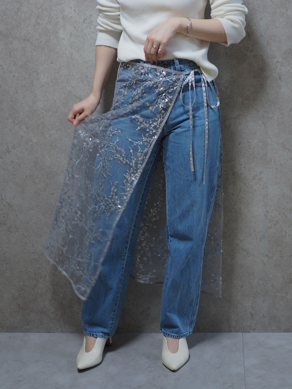 ホワイト系のニット/セーター、シルバー系のスカート、ホワイト系のパンプスを着用したレディースの春コーディネートの2枚目の写真